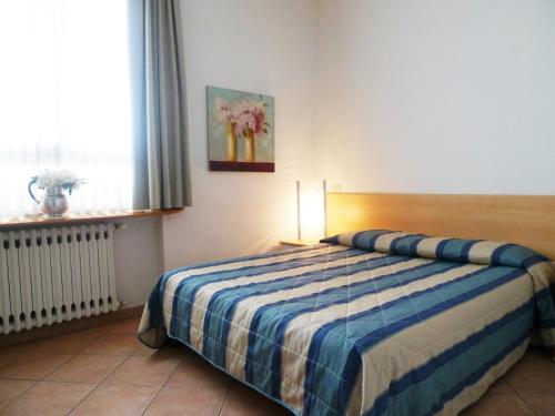 una camera da letto con un letto con una coperta a righe e una finestra di Girasole House a Firenze