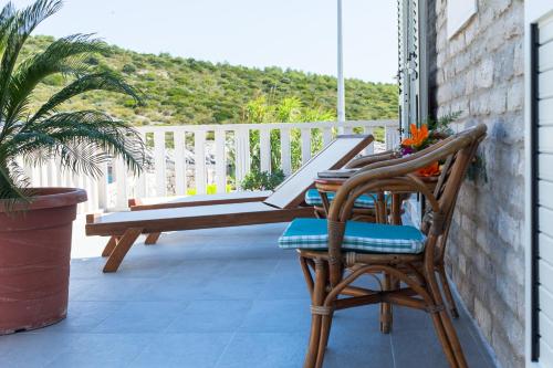a patio with a bench and two chairs on a porch at Apartments Dalmatino in Rukavac