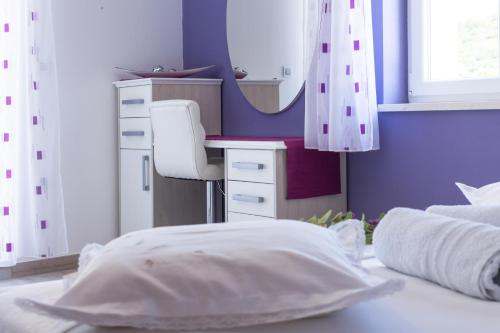 a bedroom with a bed with a desk and a mirror at Apartments Dalmatino in Rukavac