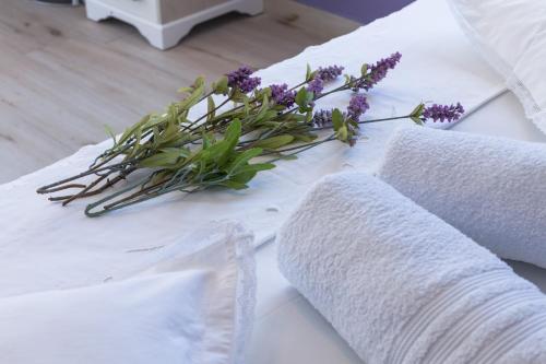 a white towel with a bunch of purple flowers on it at Apartments Dalmatino in Rukavac