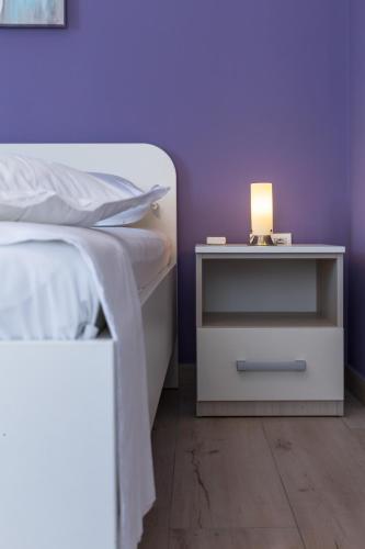 a bed with a nightstand with a lamp on it at Apartments Dalmatino in Rukavac