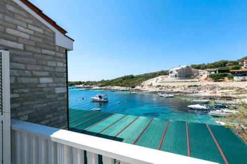 a balcony with a view of a body of water with boats at Apartments Dalmatino in Rukavac