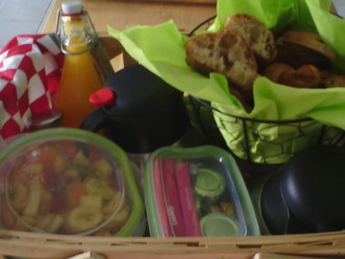 ein Tablett mit Speisen, ein Korb mit Speisen und ein Getränk in der Unterkunft Les Cabanes de Gros Bois in Prailles