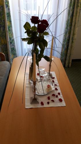 a table with a vase with roses and candles on it at Haslgut in Fuschl am See