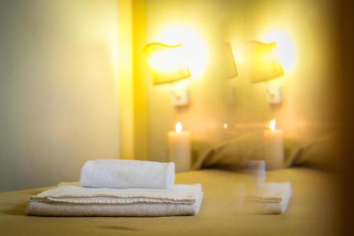 a room with a bed with two towels and a candle at Hotel Posta R.T.A. in Madonna di Campiglio