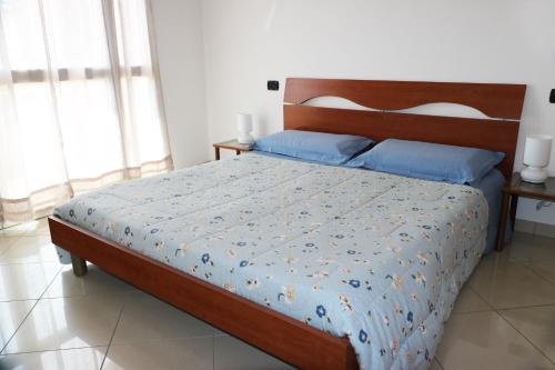 インペリアにあるCasa Altamira - fantastica vista sul mareのベッドルーム1室(大型ベッド1台、木製ヘッドボード付)