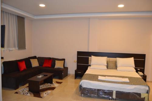 a living room with a bed and a couch at Panda Hotel Apartments in Amman
