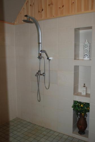 La salle de bains est pourvue d'une douche avec un pommeau de douche. dans l'établissement Hallikivi Tourist Farm, à Vennarti