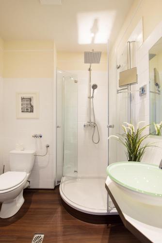 a bathroom with a shower and a toilet and a sink at Hotel Stralsund in Stralsund