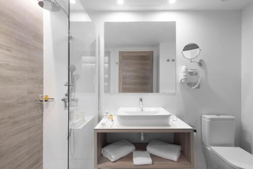 La salle de bains blanche est pourvue d'un lavabo et d'un miroir. dans l'établissement Elba Lanzarote Royal Village Resort, à Playa Blanca