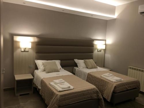 a room with two beds and two lights on the wall at Alludo Aparthotel b&b in Agrigento