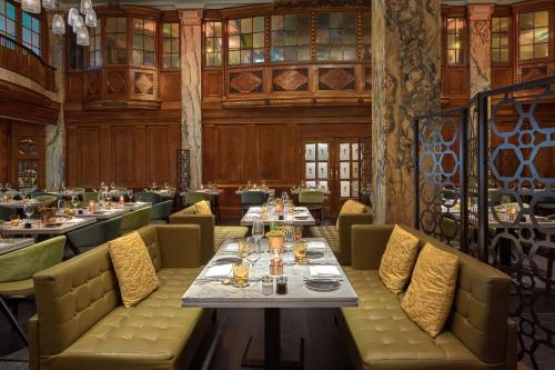 a dining room with tables and chairs in a restaurant at Reichshof Hotel Hamburg in Hamburg