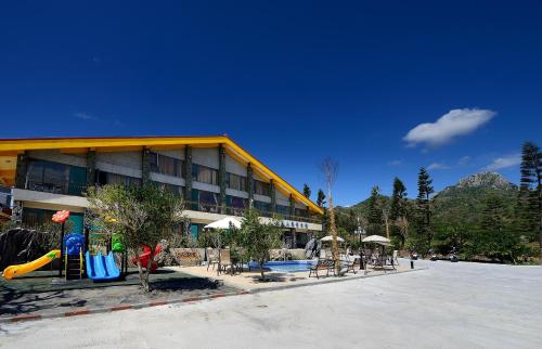 ein Hotel mit einem Spielplatz vor einem Gebäude in der Unterkunft Da Jen Shan Style Resort in Kenting