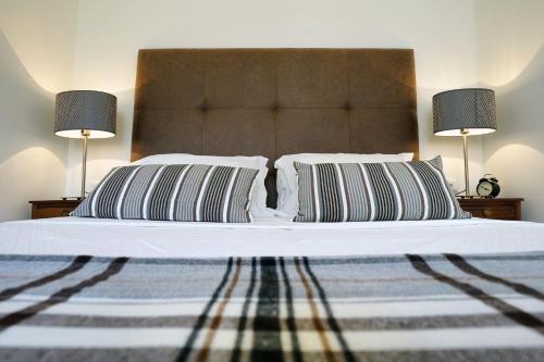 a bed with two pillows on it with two lamps at Casas de São Bento in Lisbon