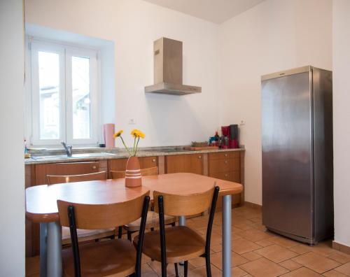 een keuken met een houten tafel en een koelkast bij Jazz Apartments in Piran