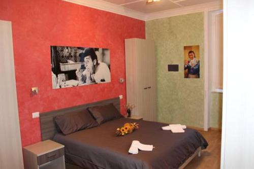 1 dormitorio con 1 cama con pared roja en B&B Central Palace King Of Rome, en Roma