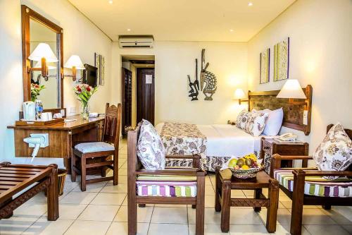 
a living room filled with furniture and a table at Baobab Beach Resort & Spa in Diani Beach
