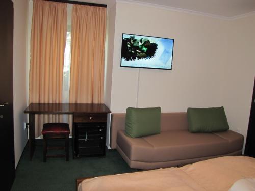 a living room with a couch and a desk at Complex Parc Pini Moinesti in Moineşti