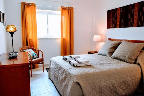 1 dormitorio con 1 cama, 1 silla y 1 ventana en Cool Country Club Apt Portimão, en Portimão