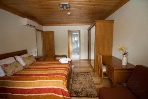 a bedroom with a bed and a desk and a table at Casa da Ribeirinha in Sabugueiro
