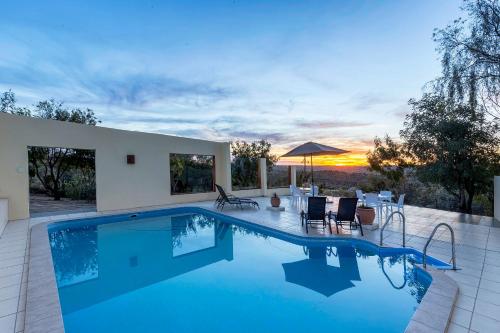 einen Pool mit Sonnenuntergang im Hintergrund in der Unterkunft Trans Kalahari Inn in Voigtland