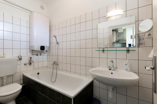 La salle de bains blanche est pourvue d'un lavabo et de toilettes. dans l'établissement East Station Studios - Baross Home 1 & 2, à Budapest