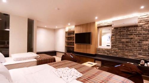 um quarto de hotel com duas camas e uma parede de tijolos em Vins 70 Hotel em Busan