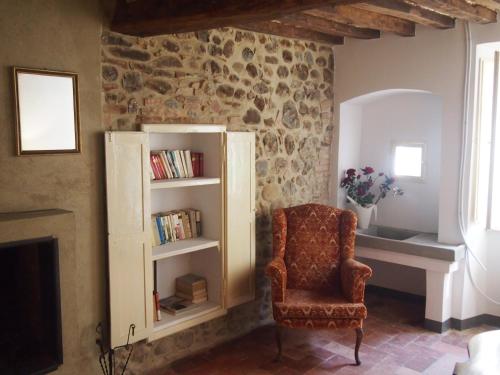 een woonkamer met een stoel en een boekenplank bij Dalle Stelle in Ficulle