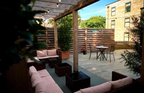 a patio with a couch and chairs and a table at The Lodge Hotel - Putney in London