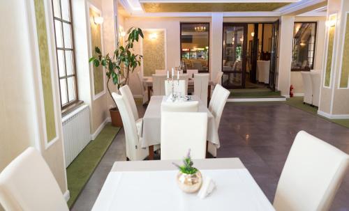 a dining room with white tables and white chairs at Complex Parc Pini Moinesti in Moineşti