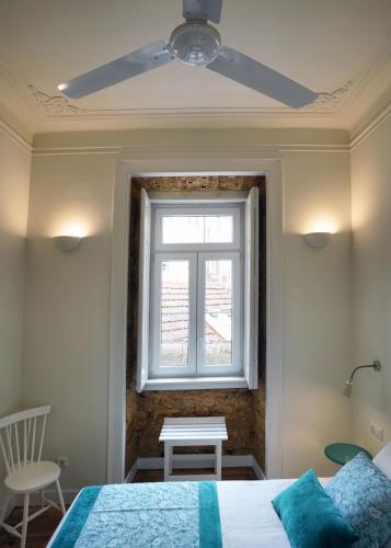 a bedroom with a ceiling fan and a window at Casas de São Bento in Lisbon