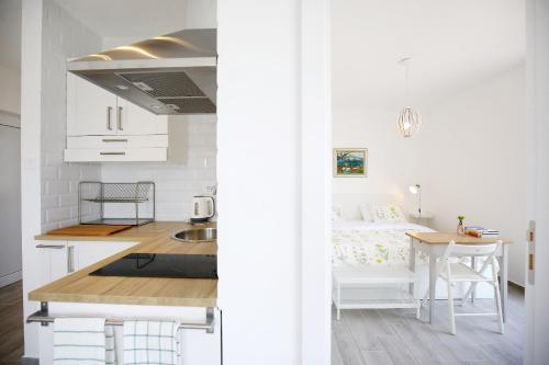 eine Küche und ein Schlafzimmer mit einem Bett und einem Tisch in der Unterkunft Apartments Villa Navi in Bibinje