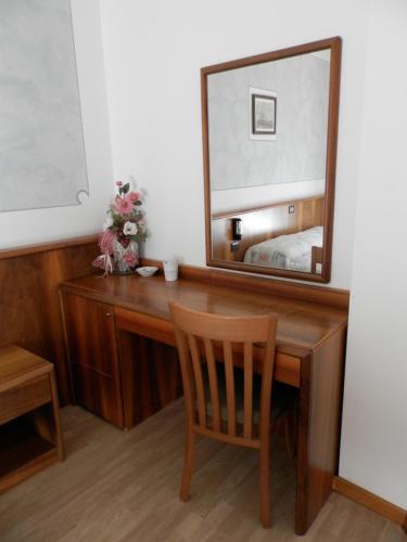 a wooden desk with a mirror and a chair at Continental Hotel in Lovere