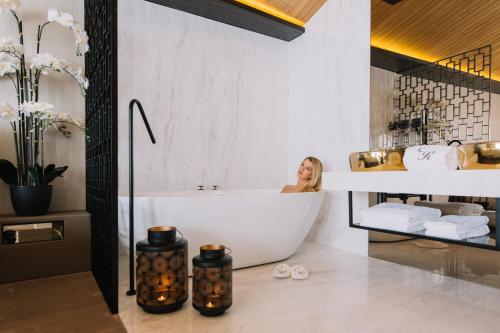 uma mulher sentada numa banheira na casa de banho em Casa do Rio charm suites em Vila do Conde