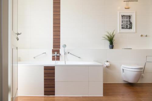 a white bathroom with a sink and a toilet at Hotel Stralsund in Stralsund
