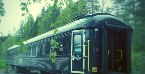 a black train is sitting on the tracks at Silleruds Station in Årjäng