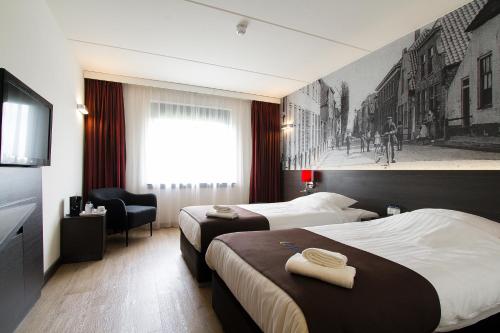 um quarto de hotel com duas camas e uma televisão em Bastion Hotel Zoetermeer em Zoetermeer