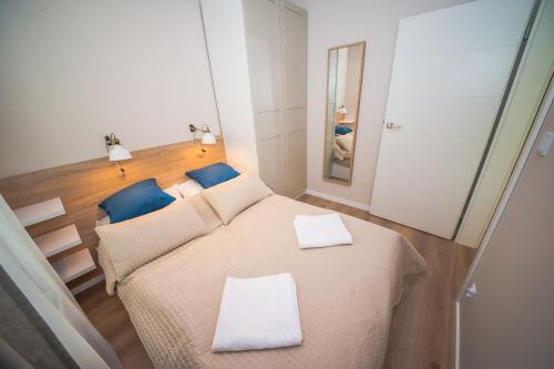 Habitación pequeña con cama y espejo. en Apartament Morski, en Ustronie Morskie