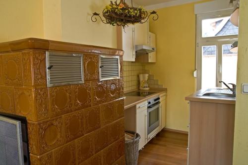 a kitchen with yellow walls and a sink and a window at Am Kleinsten Haus in Wernigerode