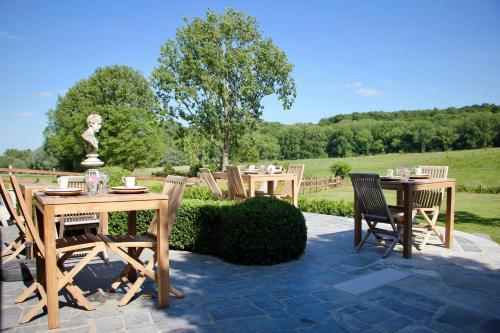 a patio with tables and chairs and a statue at B&B Het Stille Genoegen in Brakel