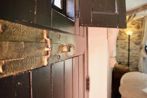an open door with a rusty latch on a wall at B&B Het Stille Genoegen in Brakel