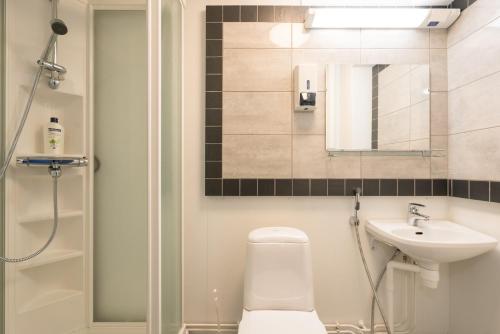a bathroom with a toilet and a sink and a shower at Gasthaus Patruuna in Joutseno