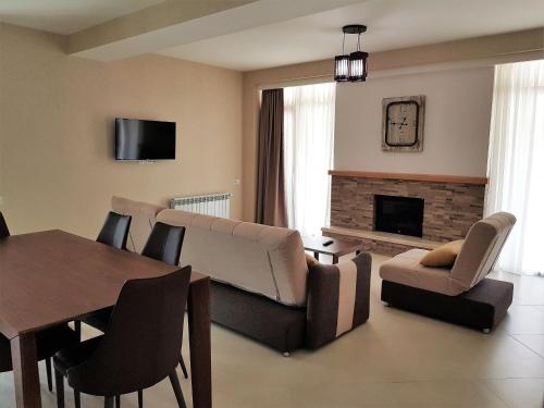 a living room with a couch and a table and a fireplace at Crystal Town House in Bakuriani