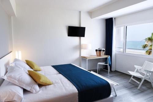 a bedroom with a bed with a view of the ocean at Hotel Agaró in Chipiona