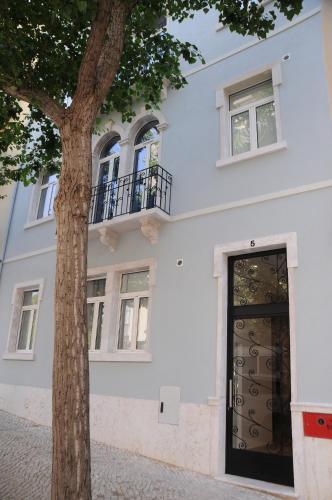 a white building with a door and a tree at Lisbonne Appartements in Lisbon