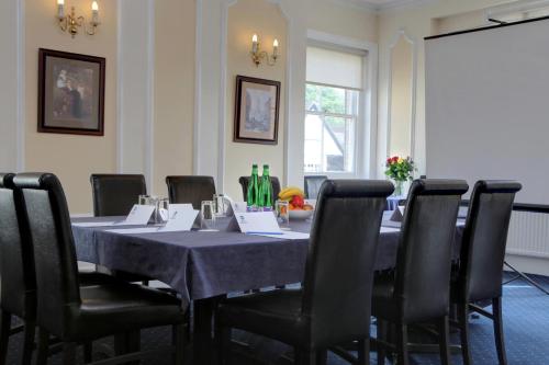 a conference room with a table with chairs and bottles at Best Western Claydon Hotel in Ipswich