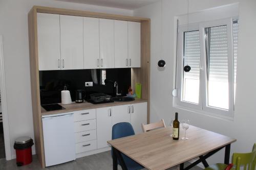 a kitchen with white cabinets and a wooden table at Apartments Grgurević in Kotor