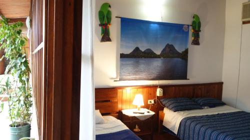 1 dormitorio con 2 camas y una foto en la pared en Toninas Hotel, en Puerto Inírida