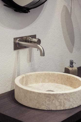a stone sink in a bathroom with a faucet at Kollmann Rooms and Apartments in Ljubljana