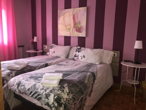 a bedroom with two beds with pink and purple stripes at Alojamientos Olga in Pamplona